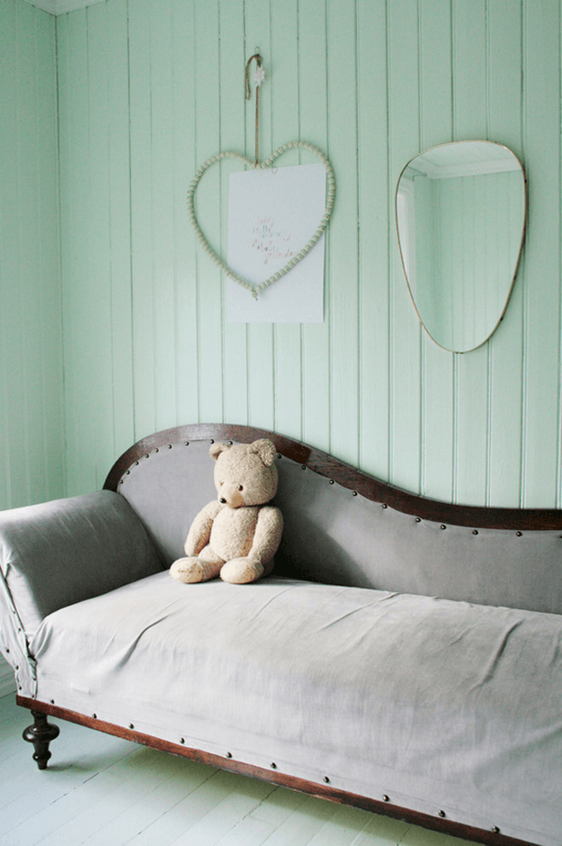 teddy bear on sofa in mint green room