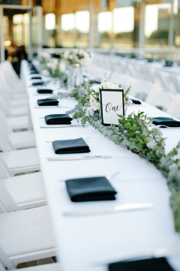 white reception table with garland and black napkins