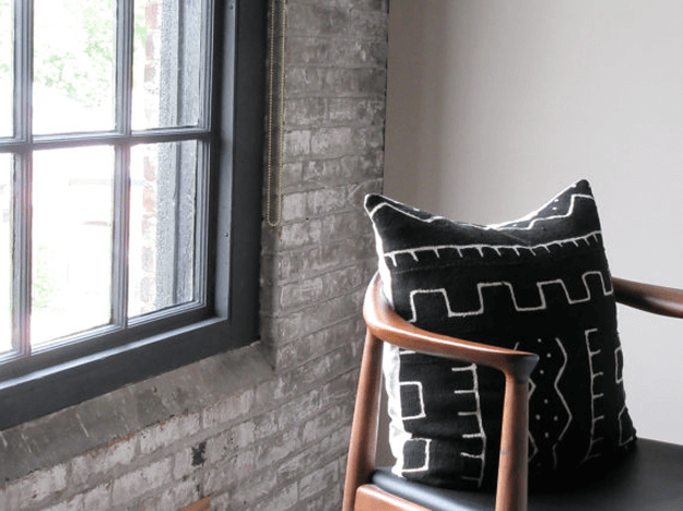black mudcloth tribal pillow on mid-century mod chair