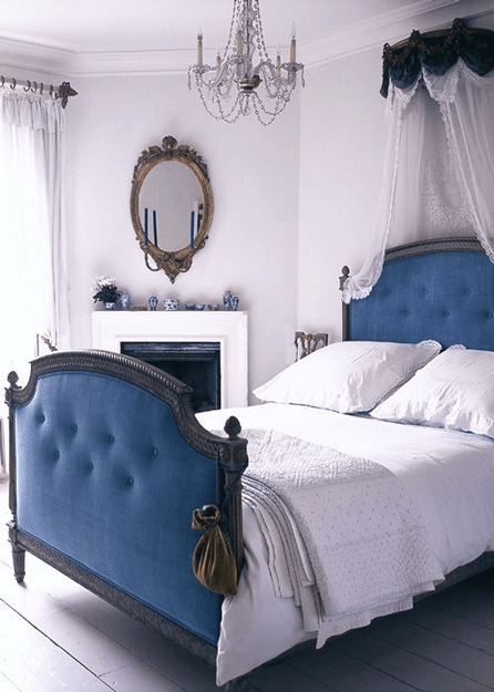 white bedroom with marine blue upholstered bed