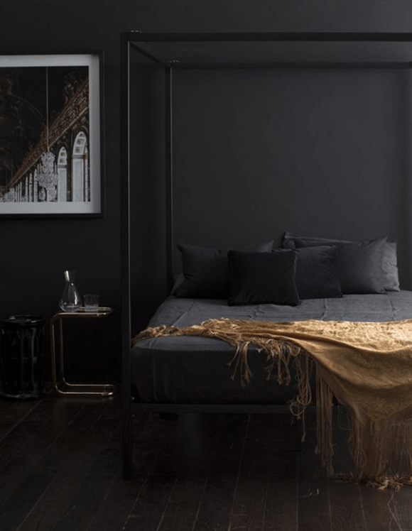 black bedroom with gold throw blanket