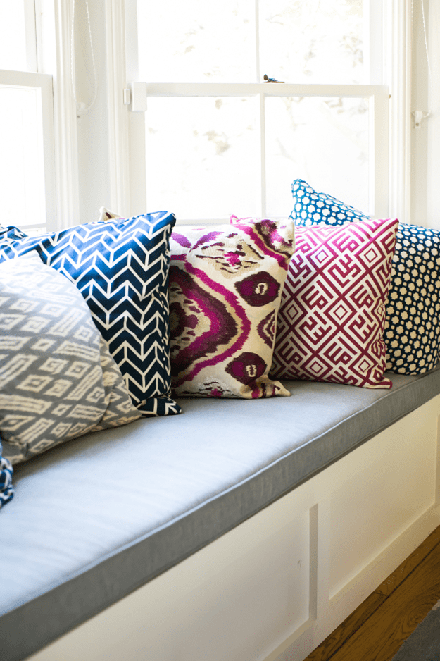 window bench with purple and navy pillows