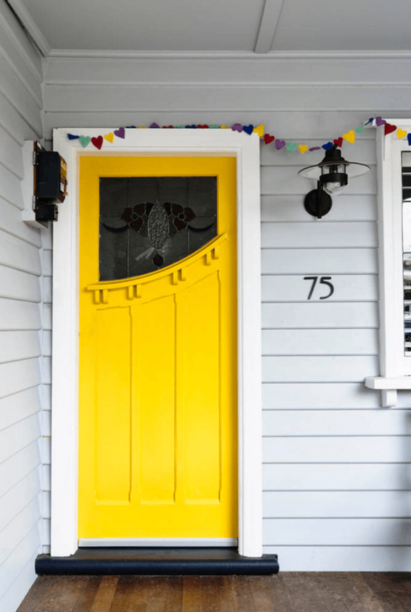 gray home white trim bright yellow door
