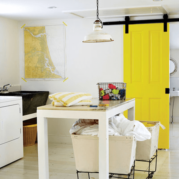 white laundry room with bright yellow barn door