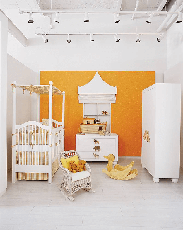 white modern nursery with orange accent wall