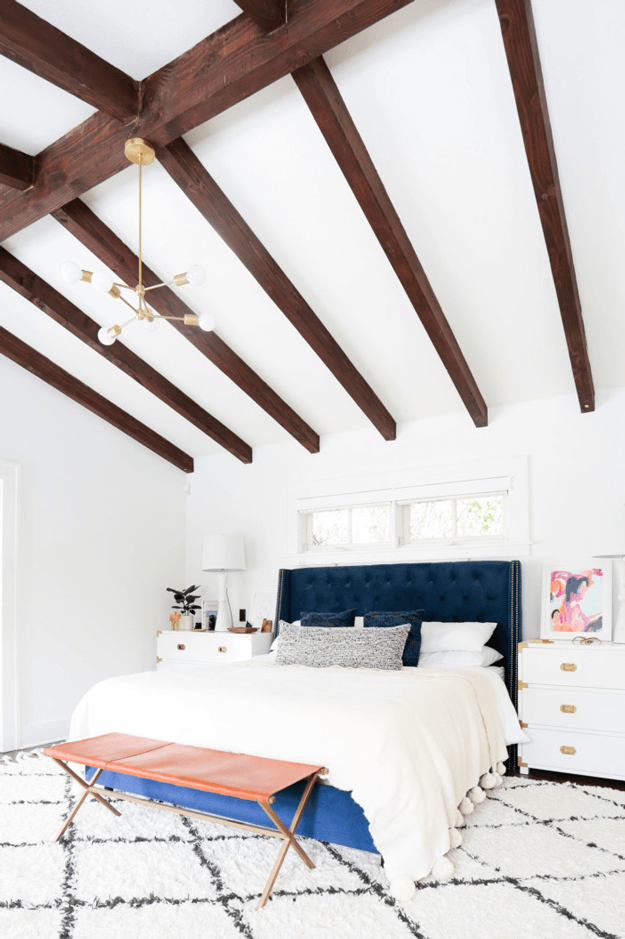 white bungalow bedroom with dark wood beams