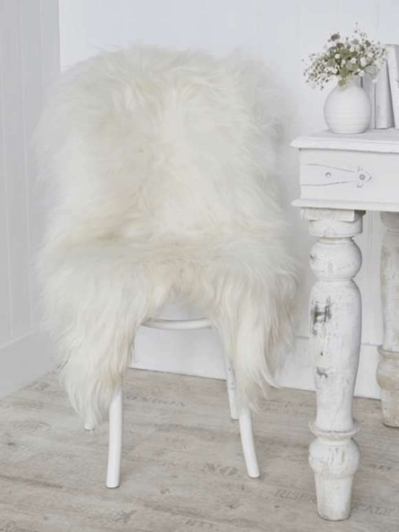 ivory white sheepskin rug draped over wood chair