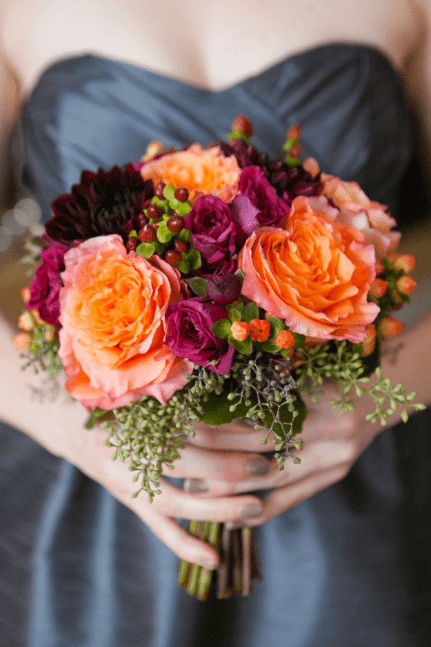 orange and plum bouquet against slate gray wedding dress