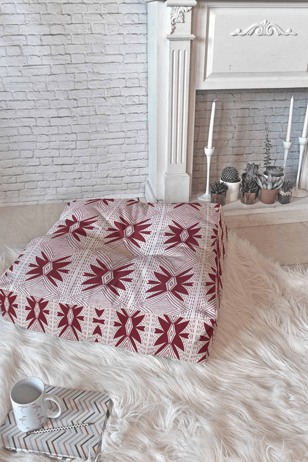 burgundy and white floor pillow in white room