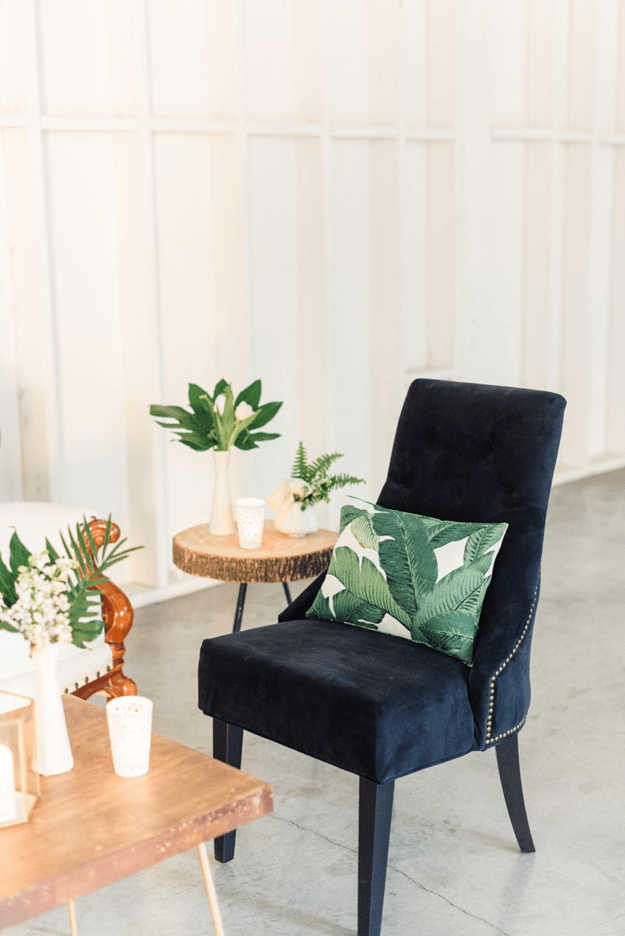 banana leaf pillow on dark navy velvet chair