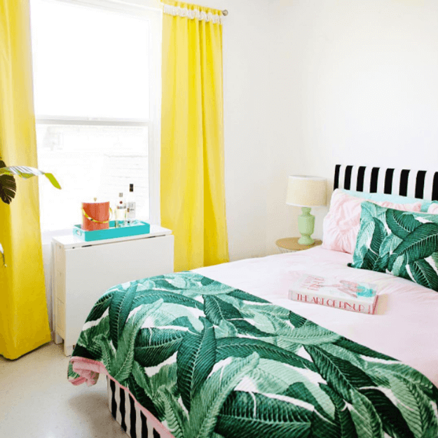 bedroom with banana leaf print and bright yellow curtains