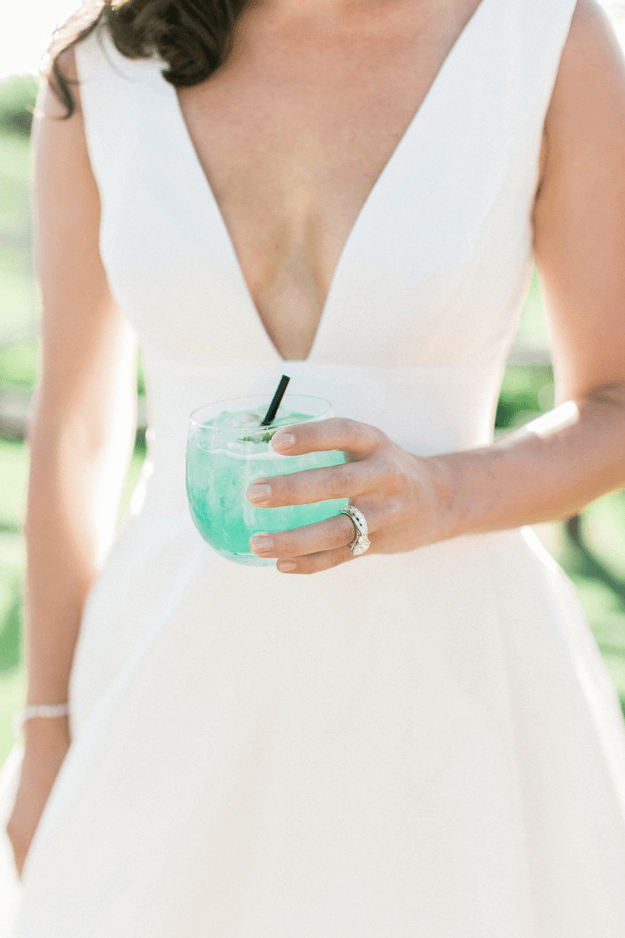 woman in white dress holding mint green drink