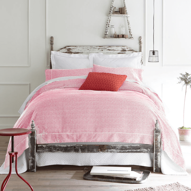 white bedroom with red bedding and vintage wood bed